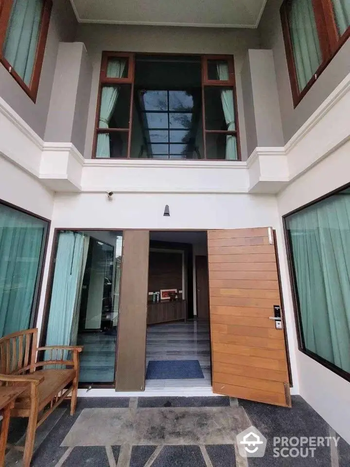 Stunning modern entrance with wooden doors and large windows