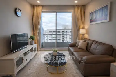 Modern living room with stylish decor, leather sofa, and city view from large window.