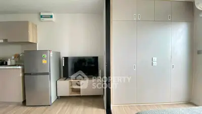 Modern apartment interior with kitchen and living area featuring sleek cabinetry and appliances.