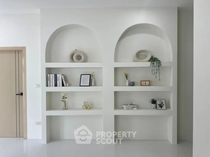 Modern minimalist living room with stylish built-in shelves and elegant decor accents.