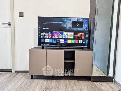 Modern living room with sleek TV stand and large flat-screen TV, perfect for entertainment.
