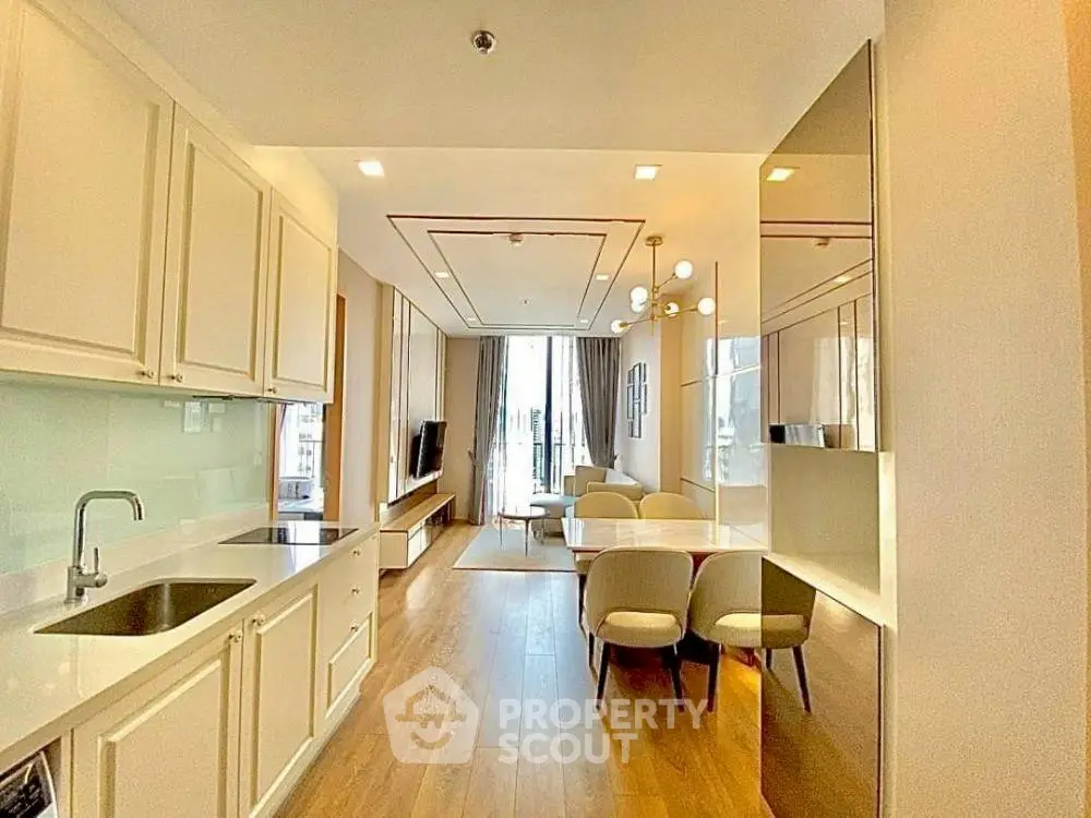 Modern open-plan kitchen and living room with elegant decor and natural light.