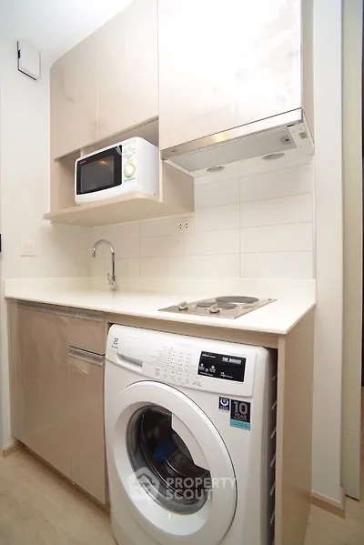Compact modern kitchen with integrated washing machine and microwave