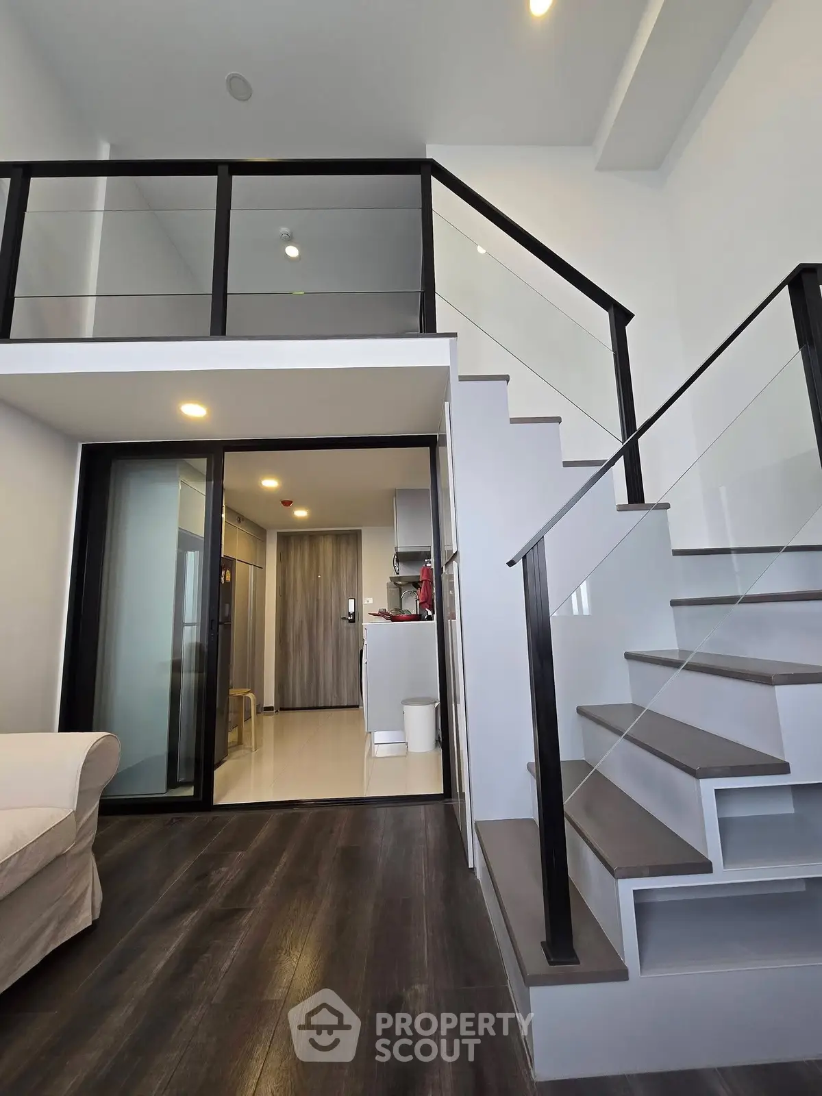 Modern loft apartment with sleek staircase and open kitchen layout, perfect for urban living.