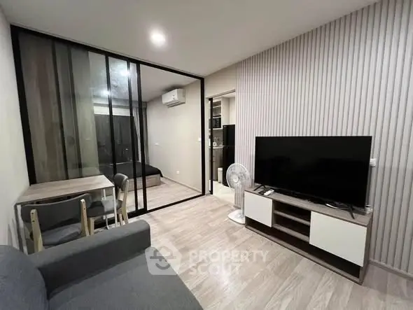 Modern living room with glass partition, sleek furniture, and cozy ambiance in a stylish apartment.