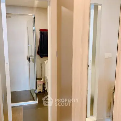 Modern bathroom with glass shower enclosure and sleek wooden accents