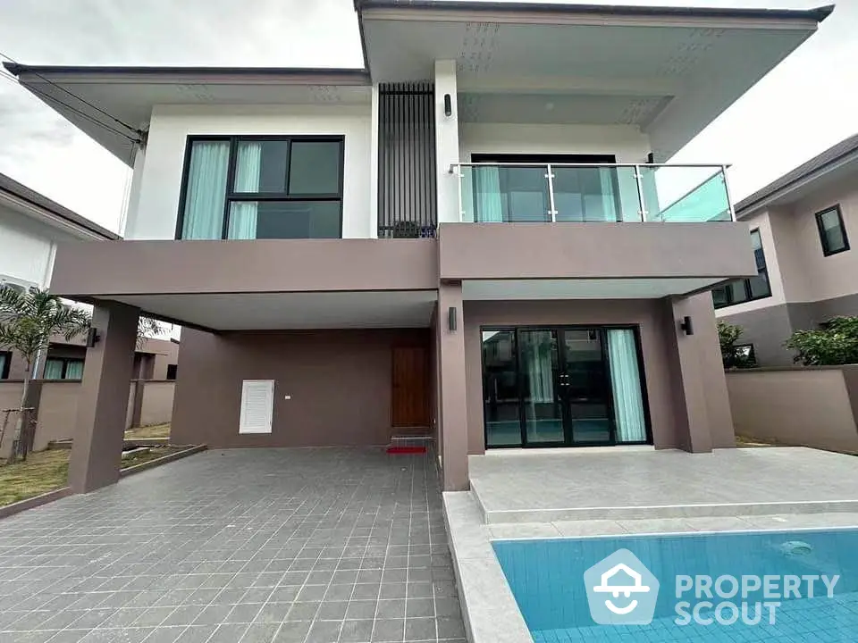 Modern two-story house with pool and spacious driveway in a serene neighborhood.