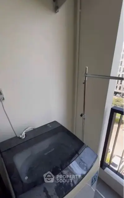 Compact balcony with washing machine and railing view