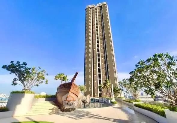 Stunning high-rise building with unique ship sculpture and lush landscaping