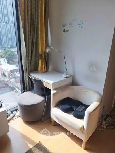 Cozy study nook with city view, featuring a desk, chair, and natural light through large window.