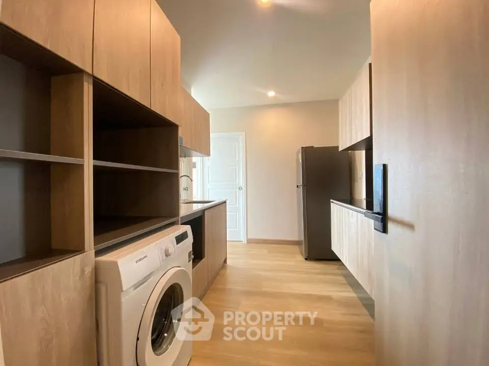 Modern kitchen with wooden cabinets and built-in washing machine