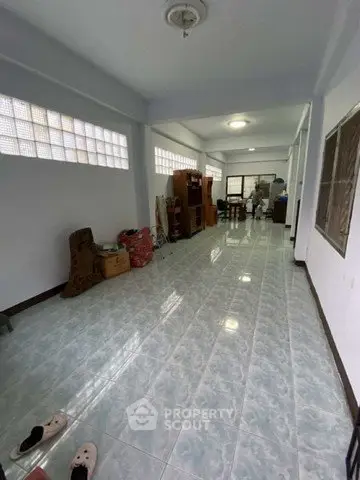 Spacious tiled room with natural light, ideal for versatile living or storage space.
