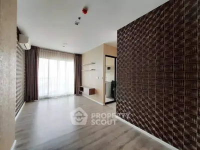 Spacious modern living room with stylish textured walls and large window for natural light.
