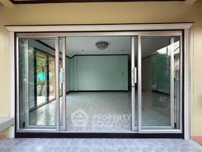 Spacious empty room with sliding glass doors and tiled flooring, perfect for customization.
