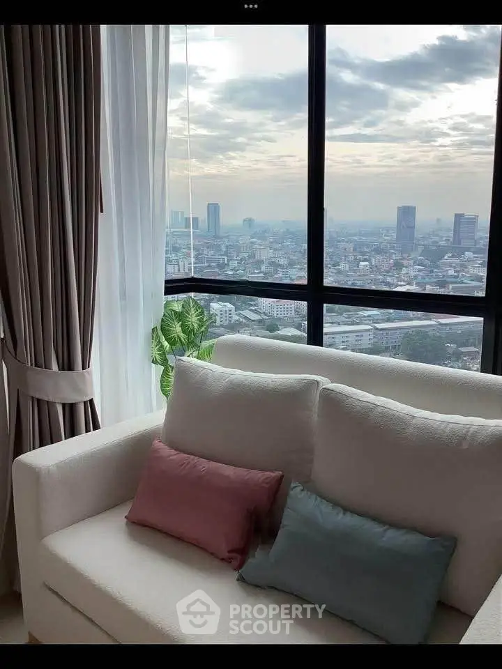 Luxurious living room with stunning city view from high-rise apartment window.