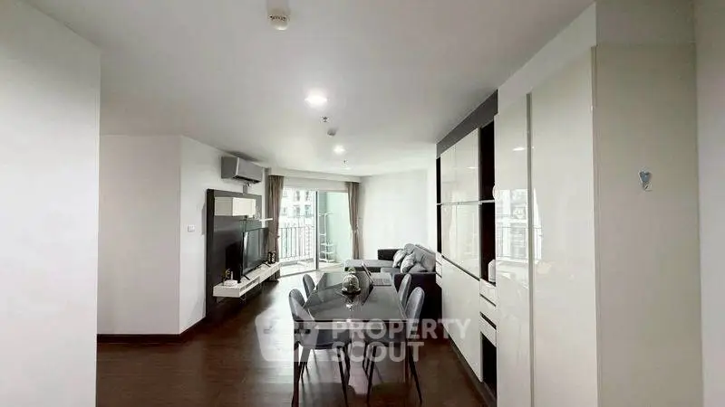 Spacious modern living room with dining area and large windows in a stylish apartment.