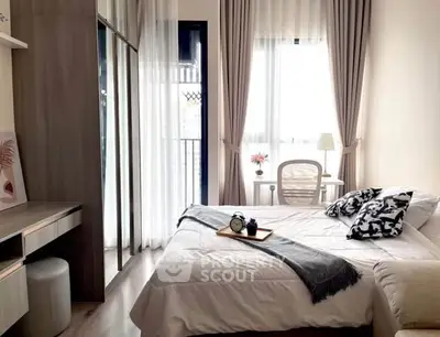 Cozy bedroom with modern decor and natural light, featuring a stylish workspace and elegant curtains.