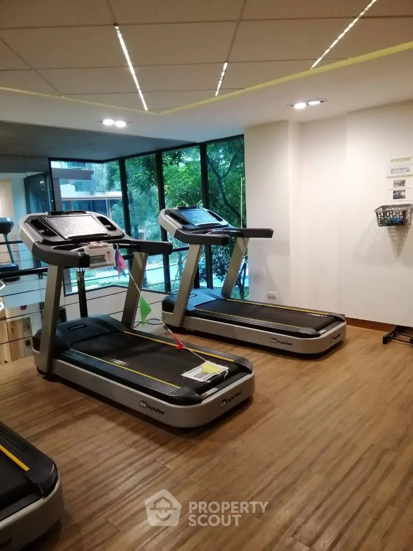 Modern gym with treadmills and large windows offering a scenic view.