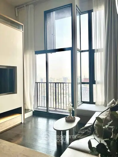 Modern living room with floor-to-ceiling windows and stunning city view.