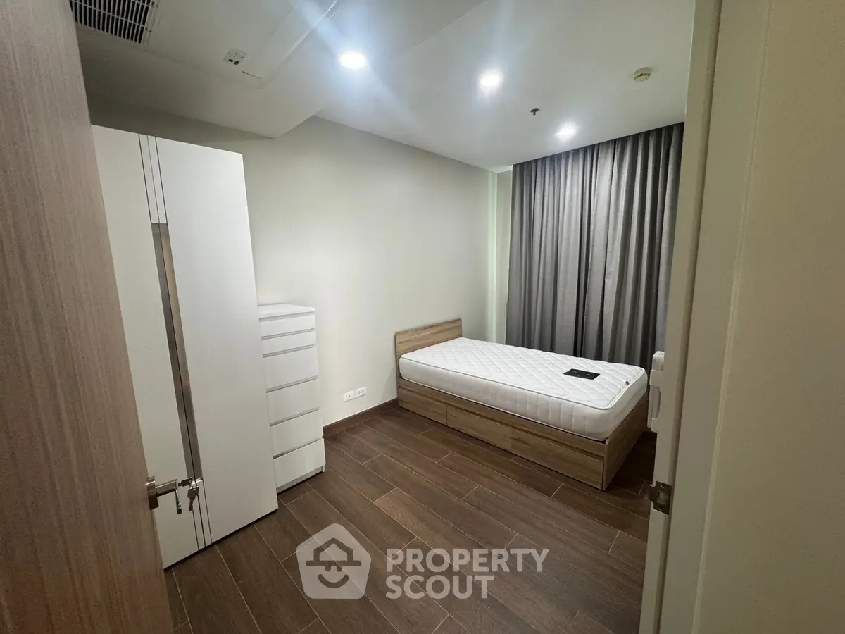 Modern minimalist bedroom with wooden flooring and sleek furniture