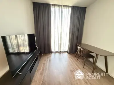 Modern study room with sleek desk and large TV, featuring floor-to-ceiling window and elegant curtains.