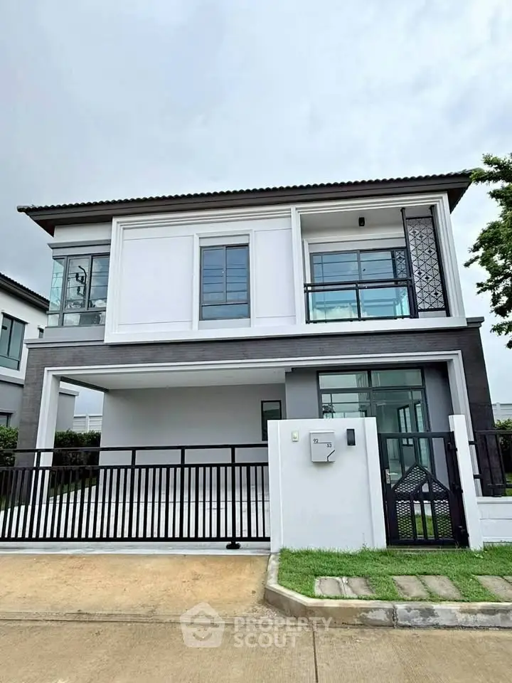 Modern two-story house with sleek design and spacious driveway in a serene neighborhood.