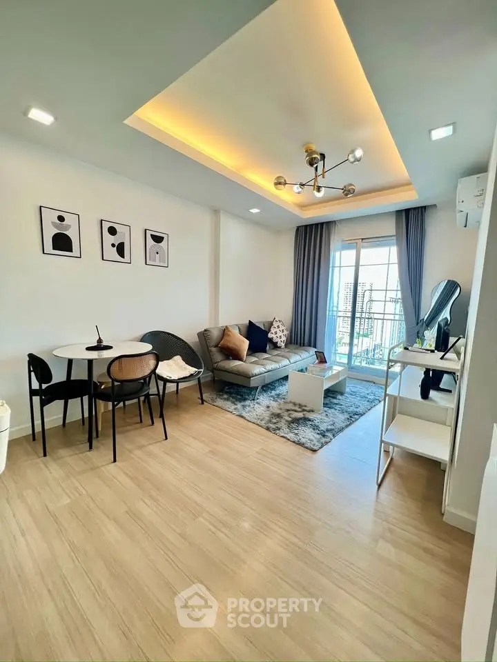 Modern living room with stylish decor, cozy seating, and balcony view in a contemporary apartment.