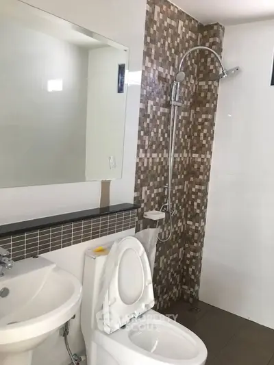 Modern bathroom with stylish mosaic tile shower and sleek fixtures