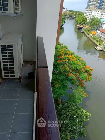 Charming balcony with serene river view and lush greenery, perfect for relaxation.