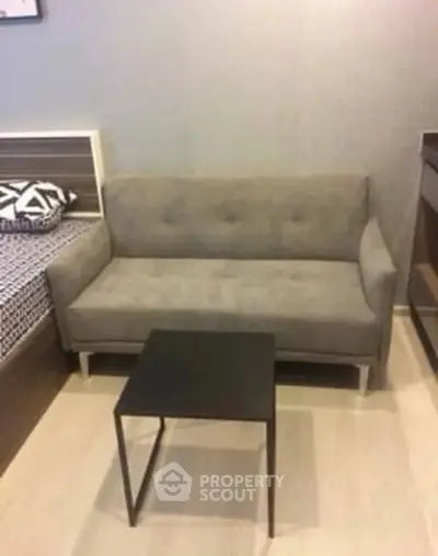 Cozy living room with modern gray sofa and sleek black coffee table.