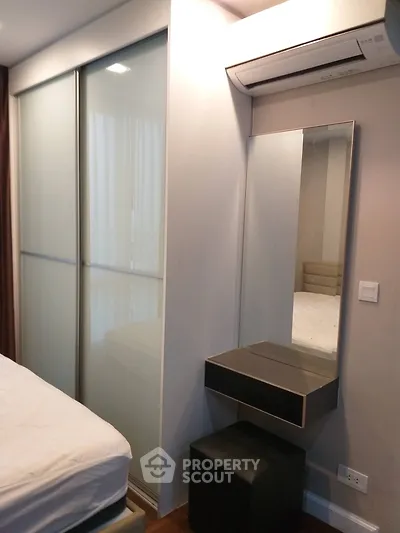 Modern bedroom with sliding closet doors and wall-mounted air conditioner