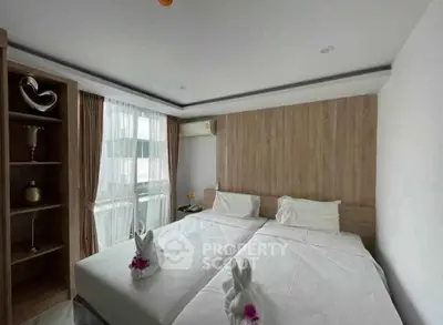 Modern bedroom with twin beds, elegant decor, and natural light from large window.
