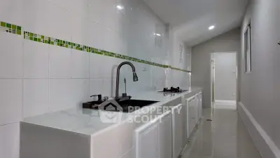 Sleek modern kitchen with white cabinetry and stylish backsplash