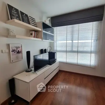 Chic modern living room with sleek TV setup and large window for natural light.