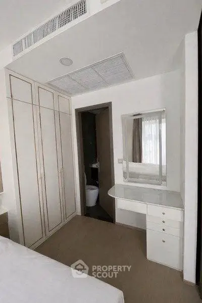 Cozy bedroom with built-in wardrobe and vanity, perfect for modern living.