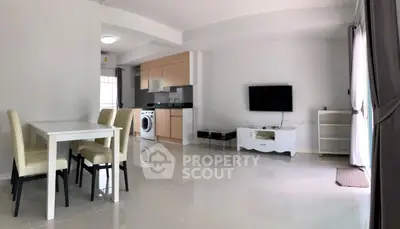 Modern open-plan living room with dining area and kitchen featuring a washing machine.