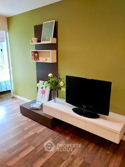 Modern living room with stylish TV unit and green accent wall