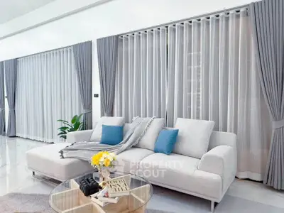 Elegant living room with modern white sofa, stylish curtains, and chic decor accents.