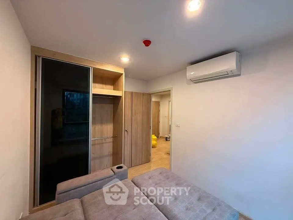 Modern bedroom with built-in wardrobe and air conditioning unit