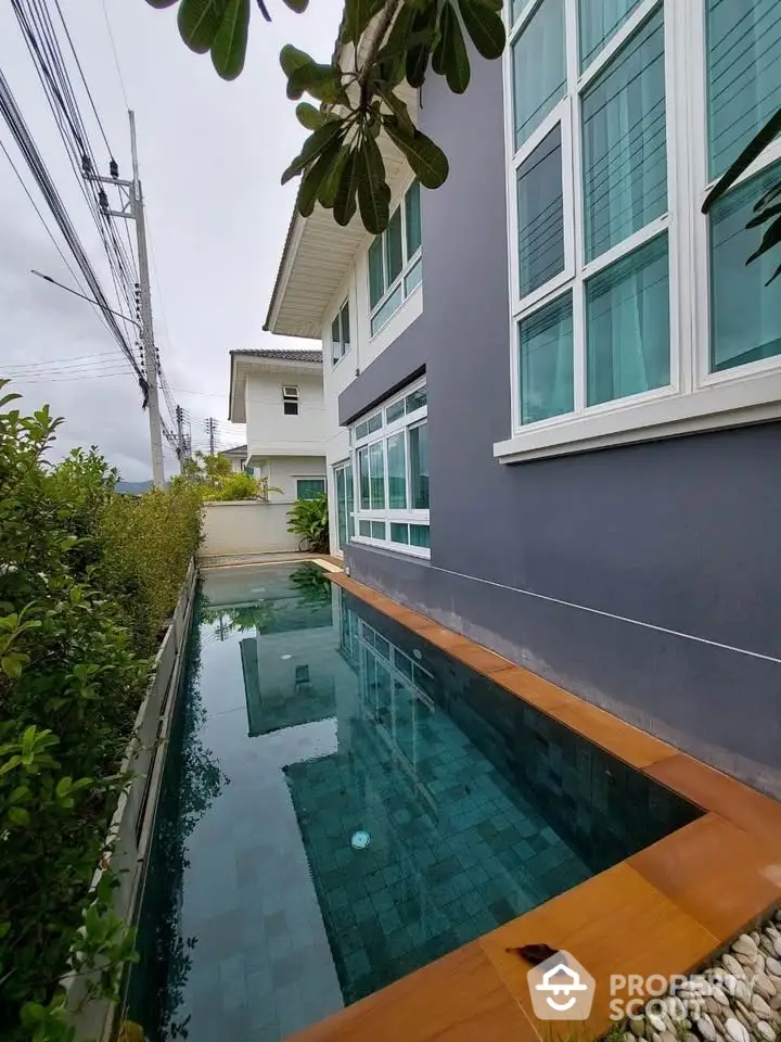 Modern house with sleek exterior and narrow pool, perfect for stylish living.