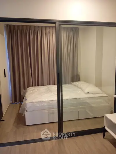 Modern bedroom with sliding glass doors and elegant curtains in a stylish apartment.