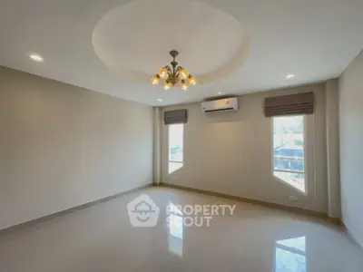 Spacious unfurnished living room with modern ceiling light and air conditioning.