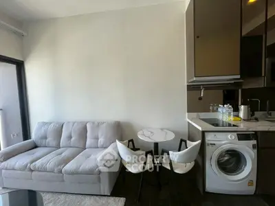 Modern living room with cozy sofa, dining set, and built-in washing machine in stylish apartment.