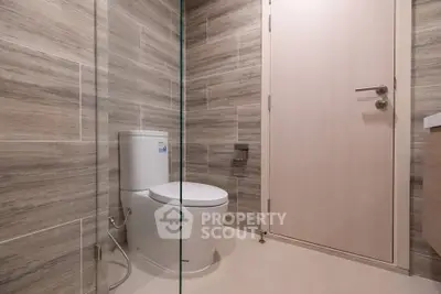 Modern bathroom with sleek design and glass shower partition.