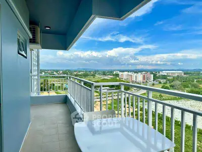 Spacious balcony with stunning panoramic view of cityscape and lush greenery.