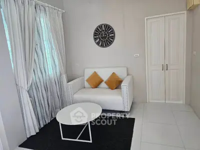 Chic living room with modern decor, featuring a stylish sofa, elegant curtains, and a contemporary wall clock.