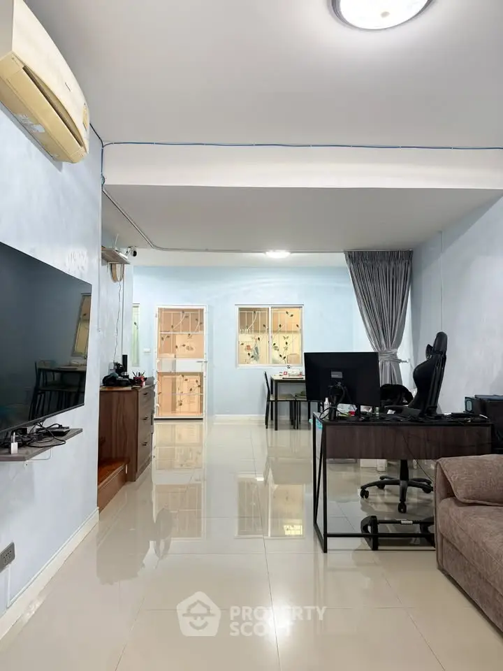 Spacious living room with modern decor and home office setup