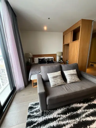 Modern bedroom with cozy sofa and stylish decor in a high-rise apartment.