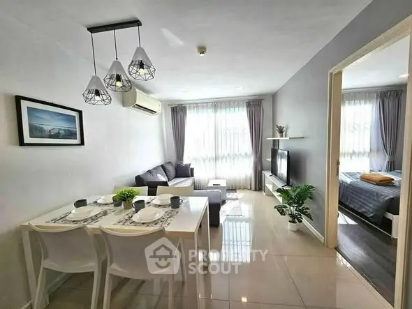 Modern living room with dining area, stylish lighting, and cozy bedroom view.