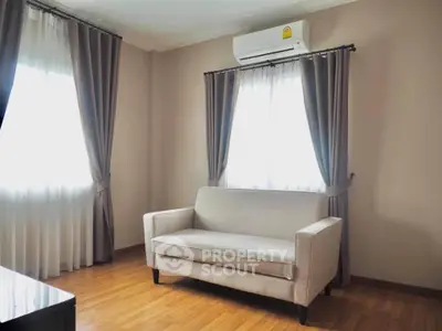 Cozy living room with elegant curtains and air conditioning, perfect for relaxation.